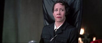 Movie still from “Austin Powers: International Man of Mystery” (1997), directed by Jay Roach – An older woman in a black jacket is sitting in a chair; Close Up shot, High angle