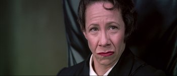 Movie still from “Austin Powers: International Man of Mystery” (1997), directed by Jay Roach – An older woman in a black suit with a red lip; Close Up shot, Low angle
