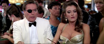 Movie still from “Austin Powers: International Man of Mystery” (1997), directed by Jay Roach – A man and a woman sitting next to each other in front of another woman; Close Up shot, Over the shoulder angle
