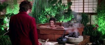 Movie still from “Austin Powers: International Man of Mystery” (1997), directed by Jay Roach – A woman sitting in a hot tub in front of a tree; Medium shot, Over the shoulder angle