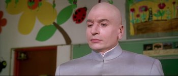 Movie still from “Austin Powers: International Man of Mystery” (1997), directed by Jay Roach – A man with bald head wearing a white suit; Close Up shot, Low angle