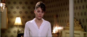 Movie still from “Austin Powers: International Man of Mystery” (1997), directed by Jay Roach – A woman in a white shirt standing in front of a wall; Close Up shot, Over the shoulder angle