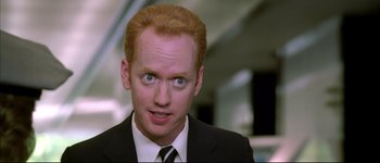 Movie still from “Austin Powers: International Man of Mystery” (1997), directed by Jay Roach – A person wearing a suit and tie; Close Up shot, Over the shoulder angle