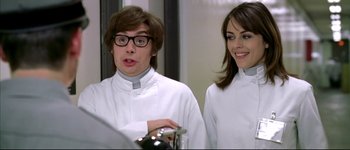 Movie still from “Austin Powers: International Man of Mystery” (1997), directed by Jay Roach – A man and a woman wearing white lab coats; Medium shot, Over the shoulder angle