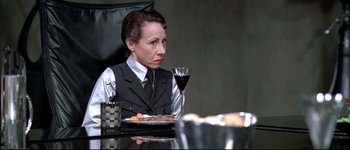 A woman sitting at a table with a glass of wine
