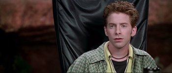 Movie still from “Austin Powers: International Man of Mystery” (1997), directed by Jay Roach – A person sitting in a chair wearing a jacket; Close Up shot, High angle
