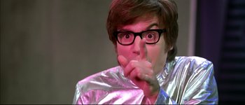 Movie still from “Austin Powers: International Man of Mystery” (1997), directed by Jay Roach – A person with glasses and a silver jacket is making a funny face; Close Up shot, Low angle