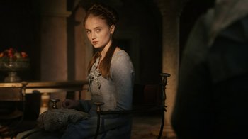 Movie still from “Game of Thrones” (2011), created by D.B. Weiss – A woman sitting on a chair in a room; Medium shot, Over the shoulder angle