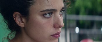 Movie still from “Stars at Noon” (2022), directed by Claire Denis – A woman's face with blue eyes; Extreme Close Up shot, Over the shoulder angle