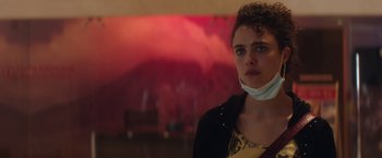 Movie still from “Stars at Noon” (2022), directed by Claire Denis – A woman wearing a face mask standing in front of a wall; Close Up shot, Over the shoulder angle