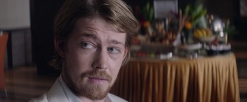 Movie still from “Stars at Noon” (2022), directed by Claire Denis – A person with a beard; Close Up shot, Over the shoulder angle