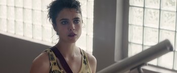 Movie still from “Stars at Noon” (2022), directed by Claire Denis – A young woman is standing in front of a mirror; Close Up shot, Over the shoulder angle