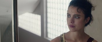 Movie still from “Stars at Noon” (2022), directed by Claire Denis – A person wearing headphones near a window; Close Up shot, Over the shoulder angle