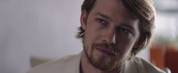 Movie still from “Stars at Noon” (2022), directed by Claire Denis – A person with a beard; Close Up shot, Over the shoulder angle