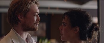 Movie still from “Stars at Noon” (2022), directed by Claire Denis – A man and a woman looking at each other in a room; Close Up shot, Over the shoulder angle