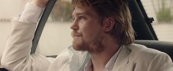 Movie still from “Stars at Noon” (2022), directed by Claire Denis – A person wearing a shirt and tie; Close Up shot, Over the shoulder angle