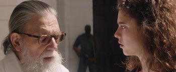 Movie still from “Stars at Noon” (2022), directed by Claire Denis – A man and a woman talking to each other; Close Up shot, Over the shoulder angle