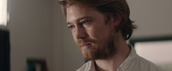 Movie still from “Stars at Noon” (2022), directed by Claire Denis – A person with a beard; Close Up shot, Over the shoulder angle