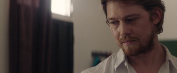 Movie still from “Stars at Noon” (2022), directed by Claire Denis – A person wearing a white shirt; Close Up shot, Over the shoulder angle