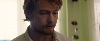 Movie still from “Stars at Noon” (2022), directed by Claire Denis – A person wearing a white shirt; Close Up shot, Over the shoulder angle