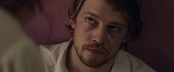 Movie still from “Stars at Noon” (2022), directed by Claire Denis – A person wearing a white shirt; Close Up shot, Over the shoulder angle