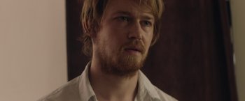 Movie still from “Stars at Noon” (2022), directed by Claire Denis – A person wearing a white shirt; Close Up shot, Over the shoulder angle