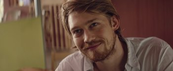 Movie still from “Stars at Noon” (2022), directed by Claire Denis – A person with long hair and a beard; Close Up shot, Over the shoulder angle