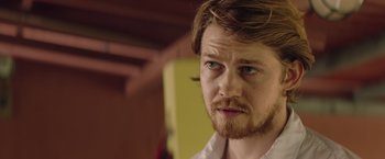 Movie still from “Stars at Noon” (2022), directed by Claire Denis – A person wearing a white shirt; Close Up shot, Over the shoulder angle