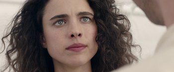 Movie still from “Stars at Noon” (2022), directed by Claire Denis – A woman's face with blue - green eyes; Close Up shot, Low angle