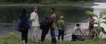 Movie still from “Stars at Noon” (2022), directed by Claire Denis – A group of people standing near a body of water; Wide shot, Over the shoulder angle