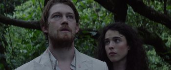 Movie still from “Stars at Noon” (2022), directed by Claire Denis – A man and a woman standing next to each other in the woods; Close Up shot, Low angle