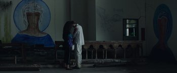 Movie still from “Stars at Noon” (2022), directed by Claire Denis – A man and a woman standing next to each other on the street; Wide shot, Over the shoulder angle