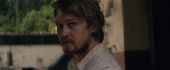 Movie still from “Stars at Noon” (2022), directed by Claire Denis – A person wearing a white shirt; Close Up shot, Over the shoulder angle