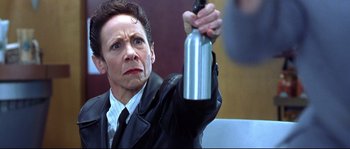 Movie still from “Austin Powers: The Spy Who Shagged Me” (1999), directed by Jay Roach – A woman holding a spray bottle in her right hand; Close Up shot, Low angle