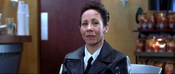 Movie still from “Austin Powers: The Spy Who Shagged Me” (1999), directed by Jay Roach – A woman in a black leather jacket is smiling for the camera; Close Up shot, Low angle