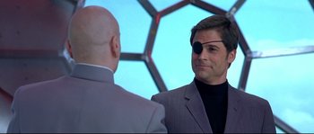 Movie still from “Austin Powers: The Spy Who Shagged Me” (1999), directed by Jay Roach – A man wearing a suit and a tie; Close Up shot, Over the shoulder angle