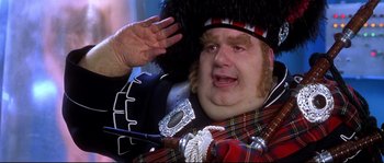 Movie still from “Austin Powers: The Spy Who Shagged Me” (1999), directed by Jay Roach – A man in a scottish outfit saluting with his hand raised; Close Up shot, Low angle