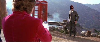 Movie still from “Austin Powers: The Spy Who Shagged Me” (1999), directed by Jay Roach – A woman taking a picture of a man standing on a hill; Wide shot, Over the shoulder angle