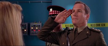 Movie still from “Austin Powers: The Spy Who Shagged Me” (1999), directed by Jay Roach – A man saluting while wearing a military uniform; Medium shot, Low angle