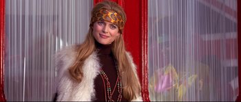 Movie still from “Austin Powers: The Spy Who Shagged Me” (1999), directed by Jay Roach – A young woman in a fur coat and a headband; Close Up shot, Over the shoulder angle