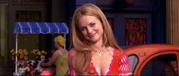 Movie still from “Austin Powers: The Spy Who Shagged Me” (1999), directed by Jay Roach – A woman with long blonde hair wearing a pink and orange dress; Close Up shot, Over the shoulder angle
