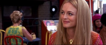 Movie still from “Austin Powers: The Spy Who Shagged Me” (1999), directed by Jay Roach – A woman with long blonde hair wearing a gold necklace; Close Up shot, Over the shoulder angle