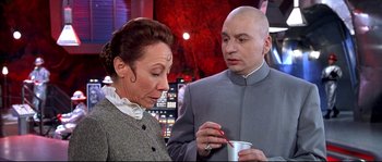 Movie still from “Austin Powers: The Spy Who Shagged Me” (1999), directed by Jay Roach – A man and a woman looking at something in a cup; Medium shot, High angle