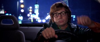 Movie still from “Austin Powers: The Spy Who Shagged Me” (1999), directed by Jay Roach – A man sitting in the back seat of a car at night; Close Up shot, Over the shoulder angle