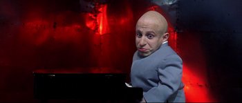Movie still from “Austin Powers: The Spy Who Shagged Me” (1999), directed by Jay Roach – A man with bald head is posing for a picture; Medium shot, Low angle