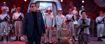 Movie still from “Austin Powers: The Spy Who Shagged Me” (1999), directed by Jay Roach – A group of men and women wearing silver suits and helmets; Medium shot, Low angle