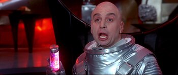 Movie still from “Austin Powers: The Spy Who Shagged Me” (1999), directed by Jay Roach – A bald man in a space suit is holding a drink; Close Up shot, Low angle