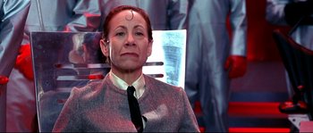 Movie still from “Austin Powers: The Spy Who Shagged Me” (1999), directed by Jay Roach – A woman in a suit and tie sitting in a chair; Close Up shot, Low angle
