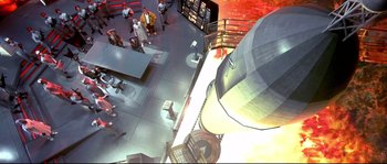 Movie still from “Austin Powers: The Spy Who Shagged Me” (1999), directed by Jay Roach – An overhead view of a building with people standing around; Extreme Wide shot, Overhead angle