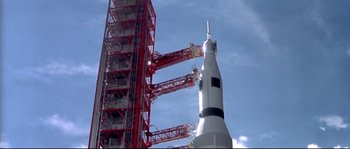 Movie still from “Austin Powers: The Spy Who Shagged Me” (1999), directed by Jay Roach – A rocket is being built in front of a red tower; Extreme Wide shot, Low angle